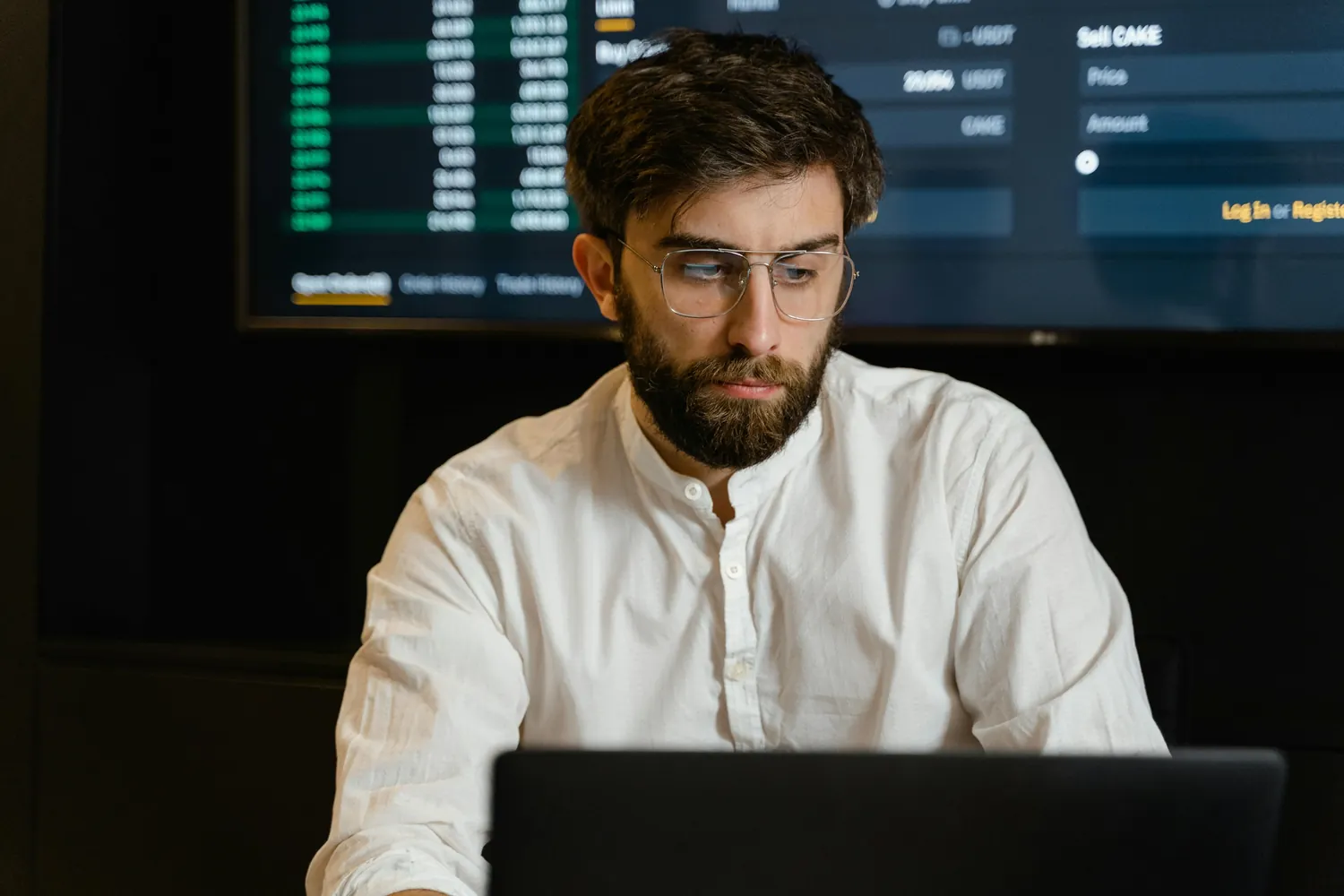 Empresário calculando o ponto de equilíbrio com gráficos financeiros.